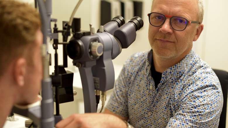 Optiker og pasient ved synsundersøkelsesutstyr
